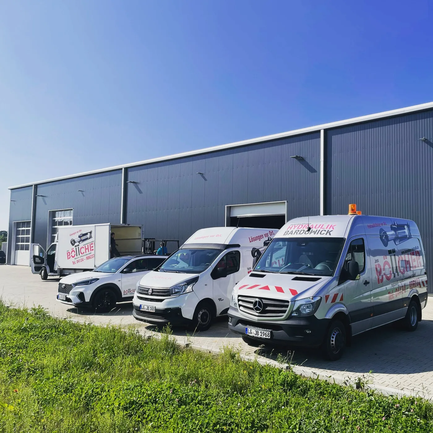 Servicefahrzeuge des Betriebs vor der Halle in Wittorf